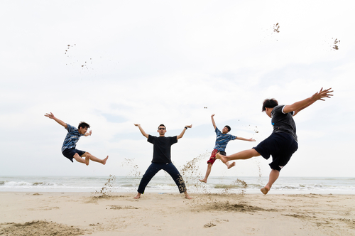 high school boys moving freely on the beach