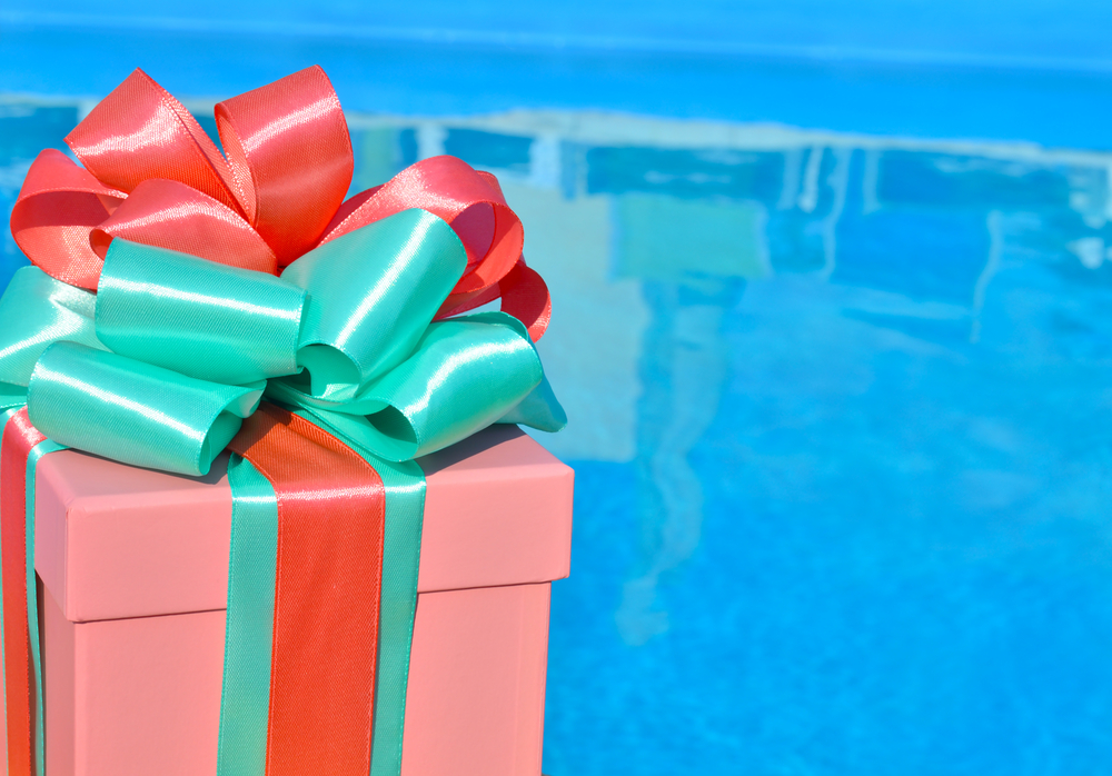 Christmas gift box against background of the blue pool